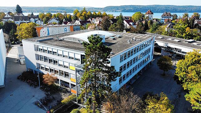 Das für den Abriss vorgesehene Gymnasium in Überlingen. Im Hintergrund glitzert der Bodensee.