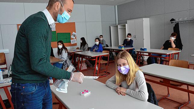 Klassenlehrer Thomas Melzer überreicht der 16-jährigen Schülerin Chiara ein Teststäbchen.