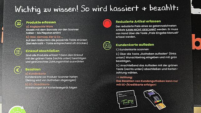 Eine Tafel erklärt: So wird kassiert und bezahlt im neuen Tante-M-Laden.