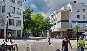 1983 kam der große Schritt aus dem Betonbau an der August-Ruf-Straße 11 auf die gegenüberliegende Straßenseite mit dem markanten Eckturm.