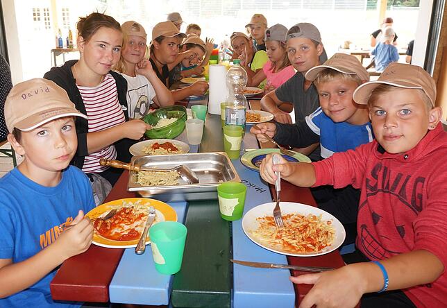 Es schmeckt: Nach dem Bauen und Spielen im Freien, treffen sich die Kinder in der Scheune zum gemeinsamen Mittagessen. Bild: Ursula Freudig