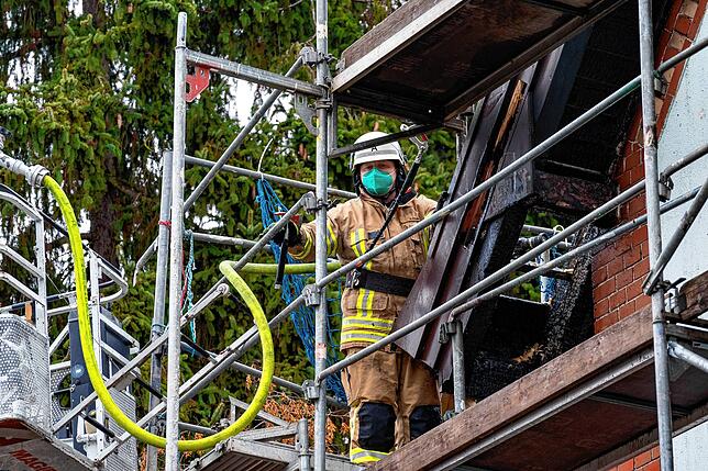 Ein Feuerwehrmann kontrolliert den Dachbereich, wo sich am Donnerstag wieder Rauch entwickelt hat.