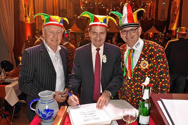 Günther Oettingers (Mitte) Eintrag ins Goldene Buch der Stadt Stockach bei der Dreikönigssitzung des Narrengerichts im Jahr 2019. ...