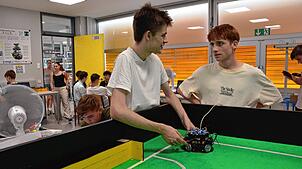 Aleksandar Vladimirov (links) und Pascal Gärtner bringen einen Fußball-Roboter aufs Spielfeld. Die technikaffinen Mitglieder der ...