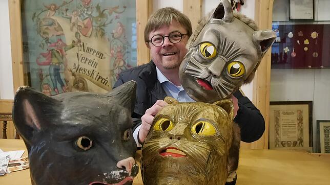 Zunftmeister Holger Schank zeigt im Zunfthaus verschiedene Katzenmasken, die dort zu begutachten sind. Die schwarze (links) diente einer ...
