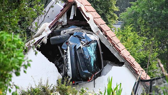 Bild 1: Auto erfasst Kind auf Trampolin und kracht in Scheunendach