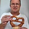 Bäcker Georg Krachenfels zeigt eine Brezel &ndash; und erklärt die Marktpreise, die auf diesem Produkt lasten .