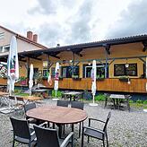Der Biergarten der Gusto Trattoria Toscana, im Hintergrund die Terrasse und der Eingangsbereich.