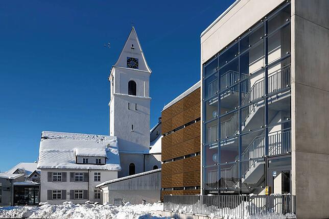Katholische Kirche Herz Jesu in Unterlauchringen mit dem neu errichteten Parkhaus (rechts) im Winter.