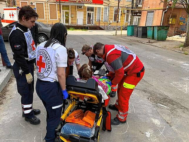 Ein aus drei Deutschen und zwei Israelis bestehendes Team nimmt in Mykolajiw eine gehbehinderte Patientin auf.