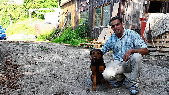Nadim Chebbi, Initiator des Waldgartens in der Stockacher Dietsche, mit Hündin Amy vor dem maroden Holzhaus, das später einmal zum ...