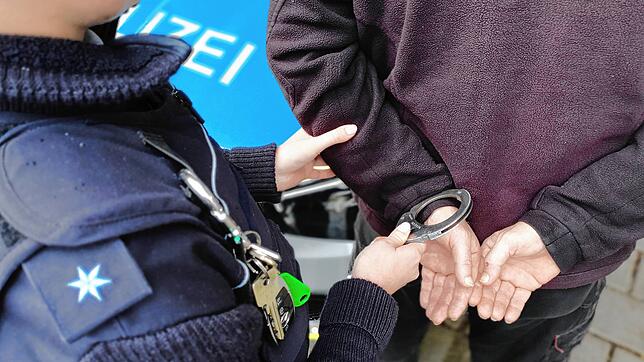 (Symbolfoto) Ein Mann wird von einem Polizisten festgenommen. Wer sich dagegen wehrt, erfüllt den Tatbestand des Widerstands gegen ...