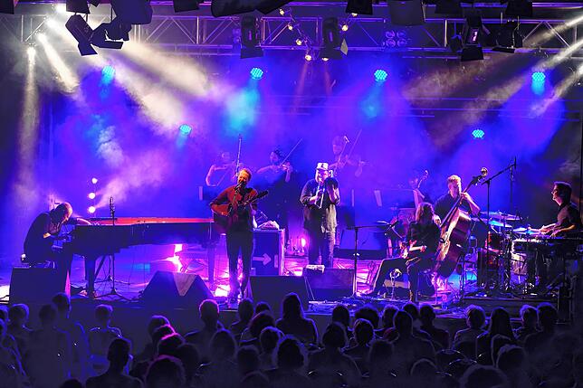 Pianist Kai Schumacher und Liedermacher Gisbert zu Knyphausen werden von einer Band aus Streichern, Posaune, Gitarre und Schlagzeug ...