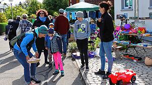 Viel Spaß haben Anbieter und Kunden beim Schuheprobieren am Stand von Familie Kaltenbach in der Eintrachtstraße. Die Straße ist eine ...