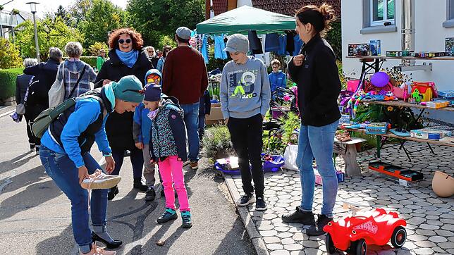 Viel Spaß haben Anbieter und Kunden beim Schuheprobieren am Stand von Familie Kaltenbach in der Eintrachtstraße. Die Straße ist eine ...