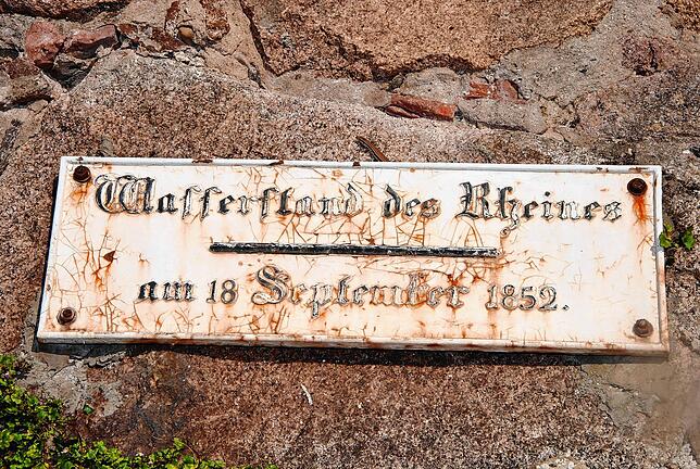 Das Schild an einer Mauer am Rheinuferweg zeigt die Hochwassermarke im Jahr 1852.