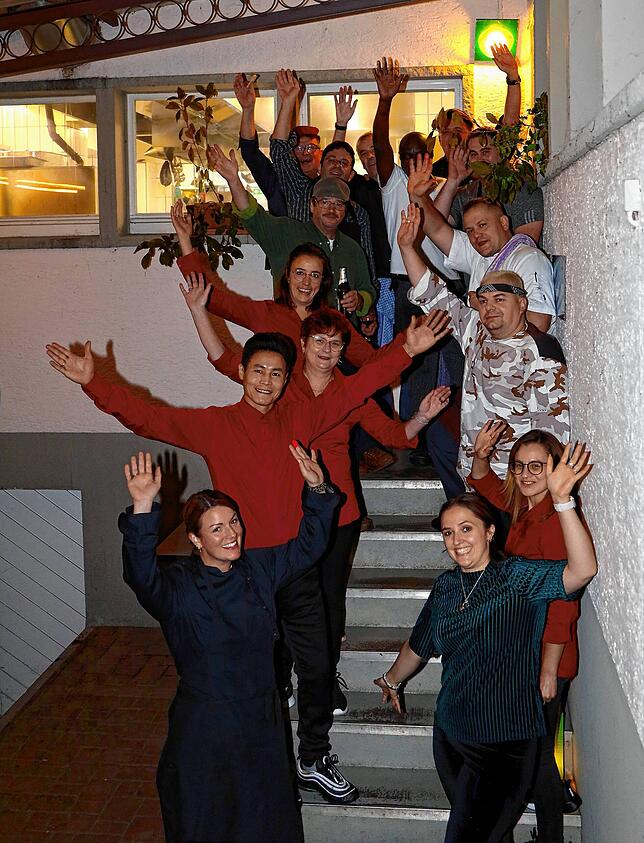 Servicekräfte und Köche auf der Treppe hinterm dem Haus.