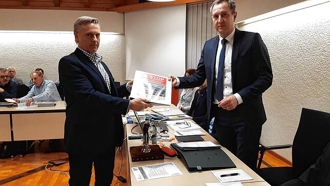 Uwe Rehnert (links), Mitglied der Interessengemeinschaft Kreuzäcker, übergibt die Unterschriften Bürgermeister Michael Schmitt.