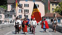 Der Gedenkzug, angeführt von den Fähnrichen, passiert die Laufenbrücke.