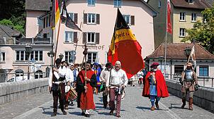 Der Gedenkzug, angeführt von den Fähnrichen, passiert die Laufenbrücke.