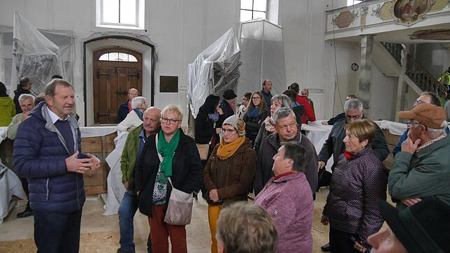 Karl Hermann (links) vom Bauförderverein St. Martin erläuterte den Besuchern die bisherigen Sanierungsmaßnahmen in der Stadtkirche.