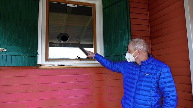 Vorsitzender Manfred Merz deutet auf das eingeschlagene Fenster über das sich die Vandalen Zugang zur Vereinshütte des SV Storzingen ...