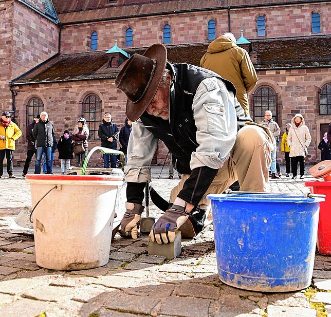 Gunter Demnig passt den Stolperstein für Ewald Huth ins Pflaster am Münsterplatz ein.