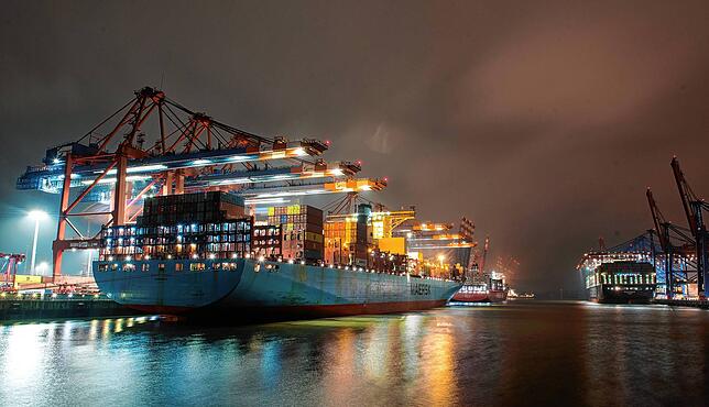 Ein Containerschiff liegt im Hamburger Hafen und wird entladen (Aufnahme mit langer Belichtungszeit).