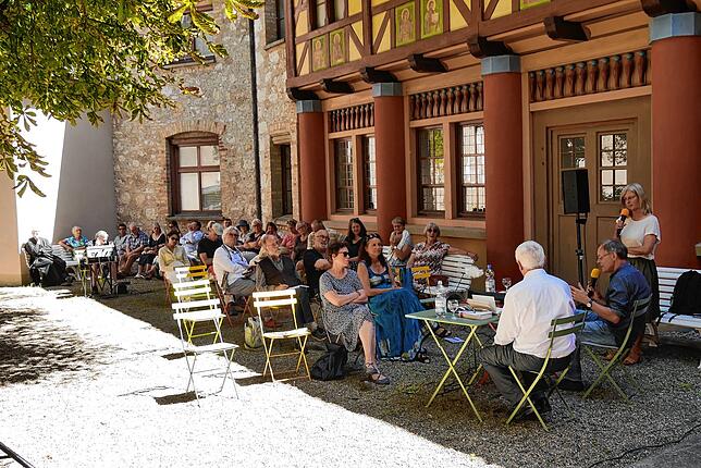 Die Zuhörerinnen und Zuhörer der Lesung drückten sich in den Schatten des Klostergebäudes mit der schmucken Fassade im Josefsgarten.