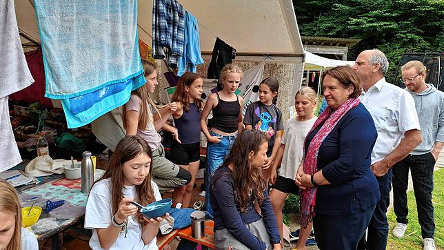 Ministerin Theresa Schopper spricht mit Kindern im Zeltlager Benistobel. Hinter Schopper steht der Landtagsabgeordnete des Wahlkreises ...