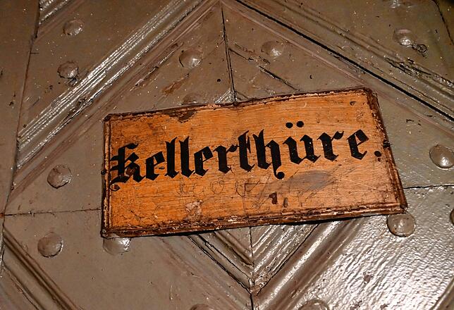 Dieses historische Schild hängt an der Kellertür unter dem Reisebüro.