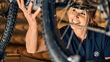 Eine ZF-Mitarbeiterin arbeitet an einem E-Bike mit Elektromotor von ZF. Mit 2,5 Kilogramm ist er sehr leicht und nicht viel größer als ...