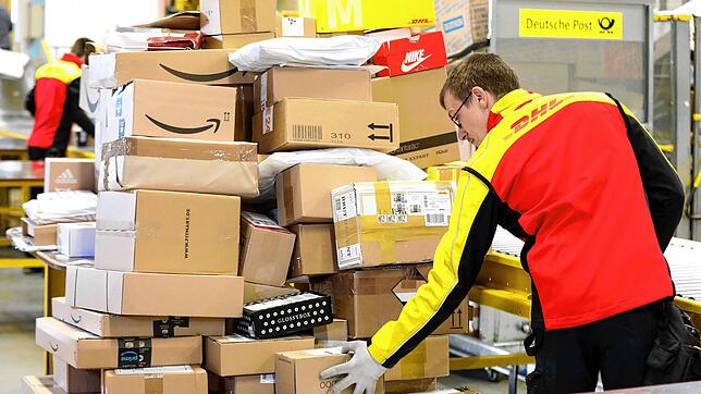 Ein DHL-Mitarbeiter sortiert Pakete in der Zustellbasis der Deutschen Post (Symbolbild). Schweizer kaufen immer öfter online im Ausland.