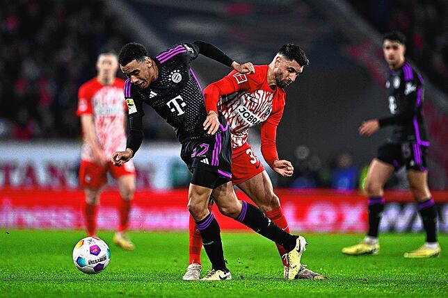 Münchens Jamal Musiala und Freiburgs Vincenzo Grifo (r) kämpfen um den Ball.