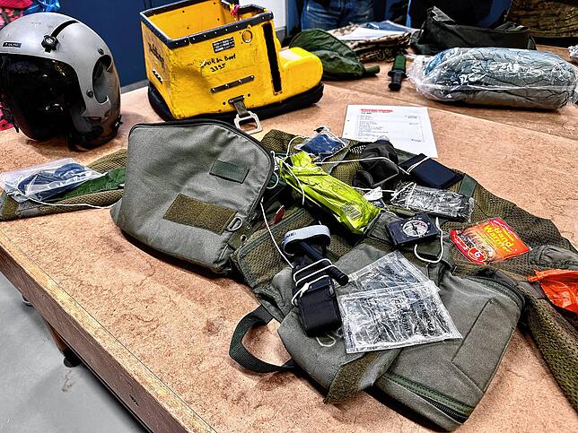 Rettungsweste und Notfallausrüstung eines Jet-Piloten. Ein Teil des Materials ist in der gelben Kiste verpackt, die am Fallschirm hängt.