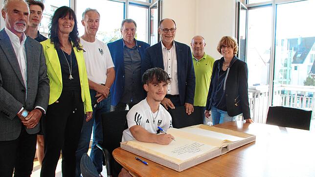 Der mehrfache Weltmeister Robin Weiler beim Eintrag ins Goldene Buch der Stadt Singen. Im Hintergrund freuen sich (von links): sein ...