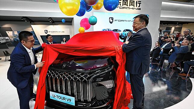 Manager der Dongfeng Liuzhou Motor Co. Ltd. enthüllen ein neues Fahrzeug der Marke Forthing beim Pressetag der Auto- und Verkehrsmesse ...
