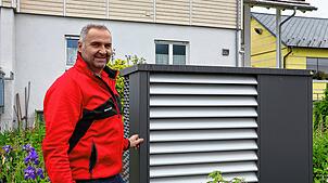 Alfred Keller neben einer Wärmepumpe, die im Garten seines Elternhauses steht. Der Handwerkschef ist überzeugt von der Technologie.