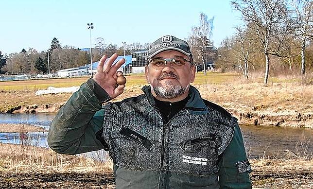 Der Kettensägenschnitzer Igor Loskutow hält eine hölzerne Murmel in der Hand. Bald können die Kugeln den hölzernen Donauverlauf der Bahn ...