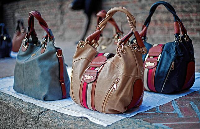 Gefälschte Designer-Taschen stehen auf diesem Archivbild auf einer Straße in Mailand. Durch die Aktivitäten von Produktfälschern ...