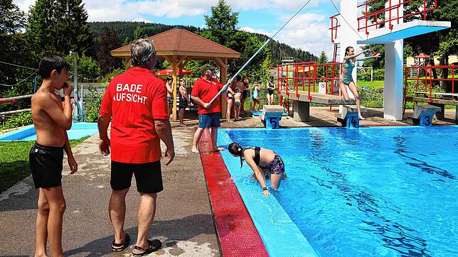 „Würstchen-Springen“ nennt Schwimmmeister Lutz Lorbeer (links) dieses Spiel, bei dem es gilt, den kleinen Ball am Ende der Angel zu ...