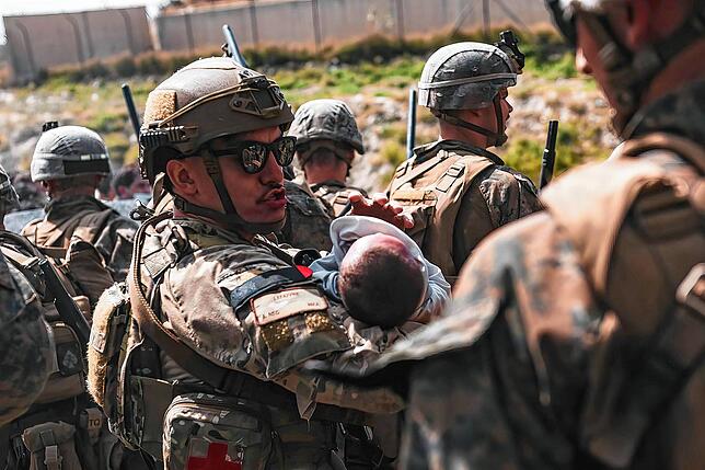 20.08.2021, Afghanistan, Kabul: In diesem vom US Marine Corps zur Verfügung gestellten Foto tröstet ein US-Soldat ein Kleinkind während ...