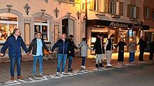 Rund 100 Menschen bilden eine Menschenkette in der Hauptstraße.