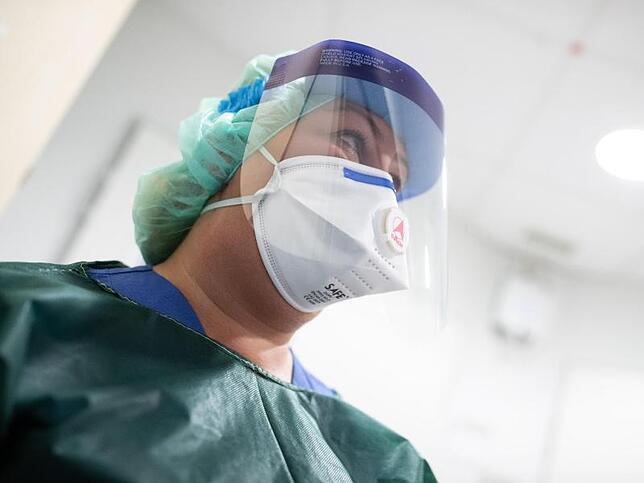 Schutzkleidung und Atemmaske: Die Mitarbeiterin einer Infektionsstation.