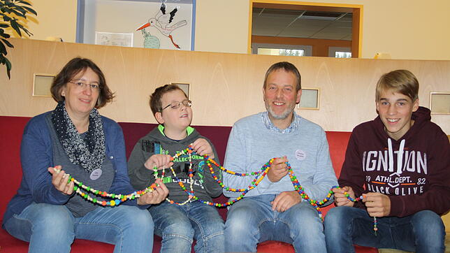 Die Kette mit den Mutperlen der Kinderkrebsstiftung ist bei Henrik (2. von links) fast acht Meter lang. Neben ihm Vater Thomas und ...