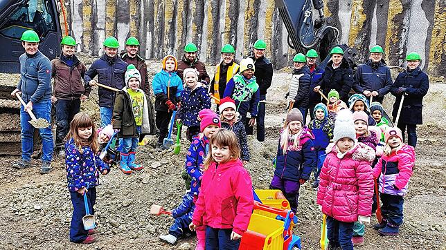 Während im Hintergund viele der Planer und Unternehmer der ersten Stunde den Spaten mit Erde in die Luft recken, buddeln die Kinder ...