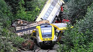 28.07.2025, Baden-Württemberg, Riedlingen: Mit einem Kran wird an der Unfallstelle an der ein Regionalzug entgleist ist ein Waggon ...