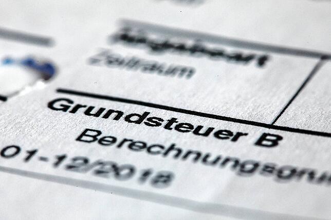 Ein Abgabenbescheid für die Entrichtung der Grundsteuer liegt auf einem Schreibtisch. Die Grundsteuer wird nach Jahrzehnten neu berechnet.