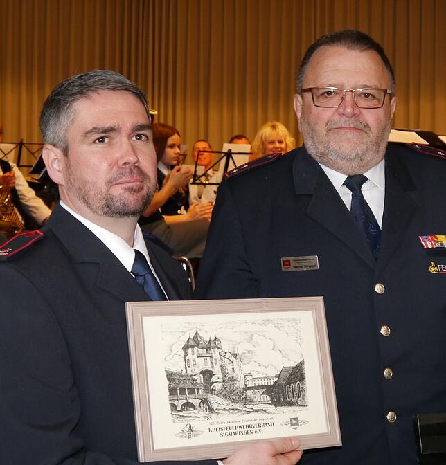 Werner Stroppel vom Kreisfeuerwehrverband (rechts) überreicht Kommandant Christian Leiss ein Bild.