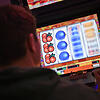 Ein junger Mann spielt an einem Spielautomaten.